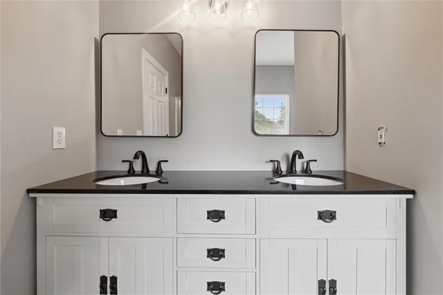 a bathroom with double sink and a mirror