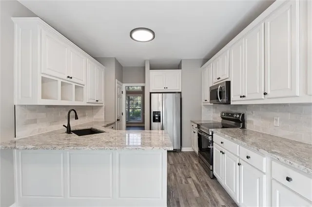 a kitchen with granite countertop a sink stove and refrigerator