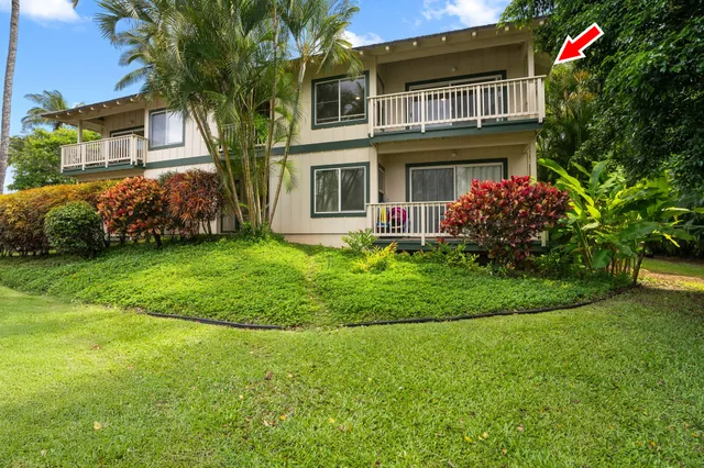a front view of a house with a garden and trees