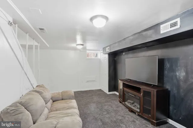a living room with furniture and a ceiling fan
