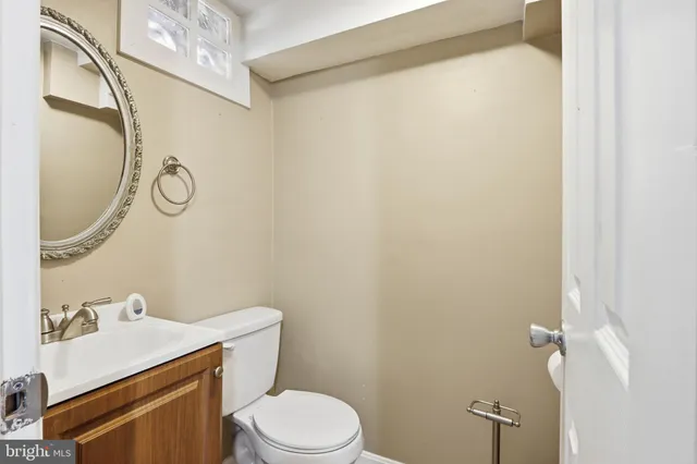 a bathroom with a sink vanity mirror and toilet