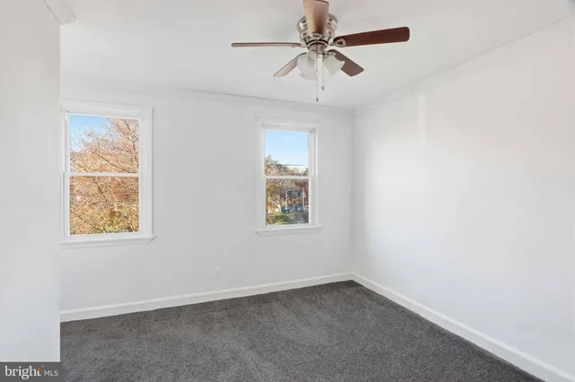 an empty room with a window and a fan