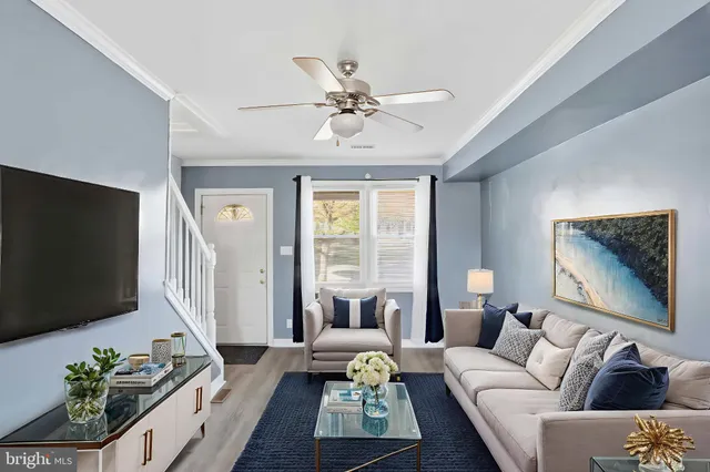 a living room with furniture a flat screen tv and a large window