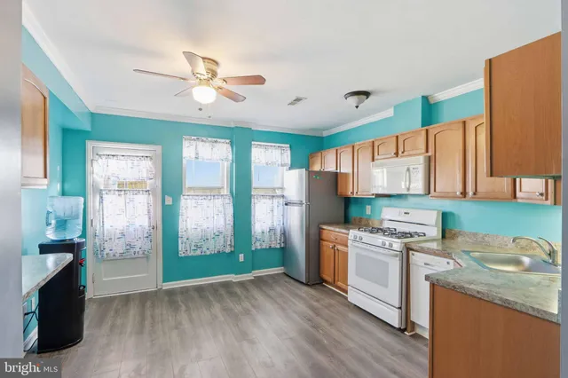 a kitchen that has a lot of cabinets and wooden floor