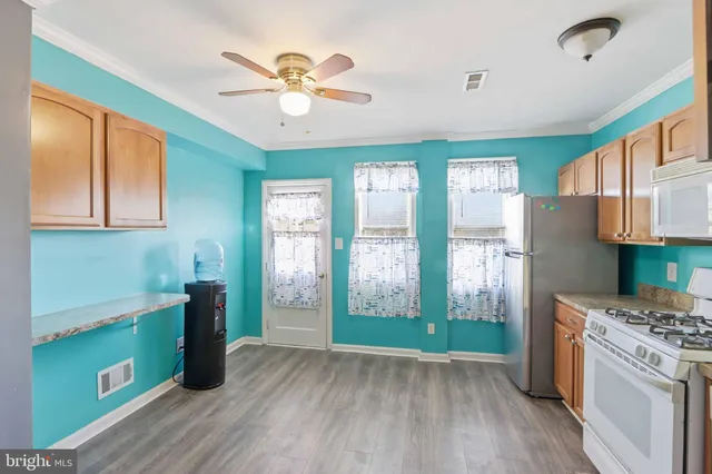 a kitchen with stainless steel appliances granite countertop a refrigerator a stove top oven a sink and dishwasher with wooden floor