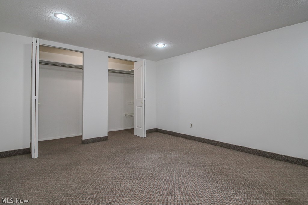 30224 Regent Road Wickliffe, OH 44092 - Photo 19 of 27 Unfurnished bedroom with two closets, dark carpet, and recessed lighting
