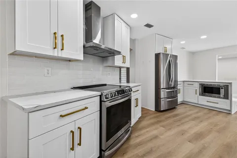 a kitchen with stainless steel appliances a stove a microwave and a refrigerator