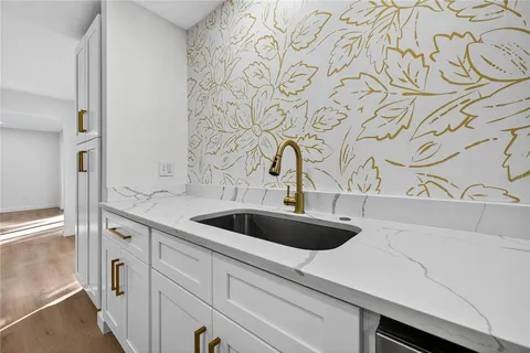 a living room with kitchen island a sink and a large window