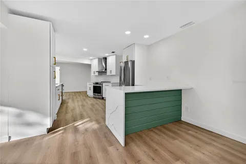 a view of an empty room with wooden floor