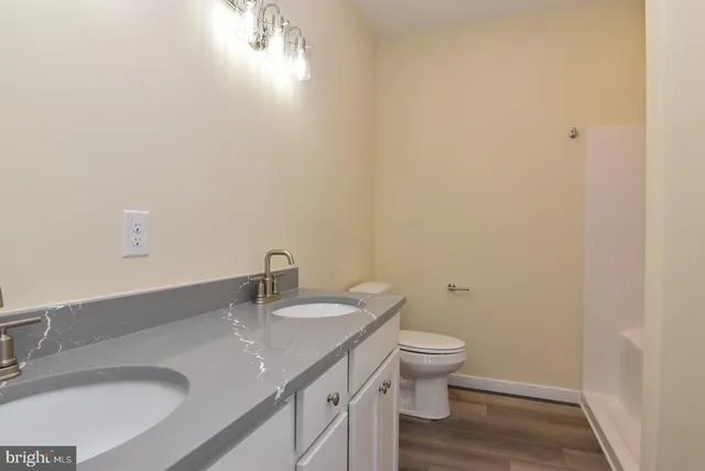 a bathroom with a granite countertop sink a toilet and a mirror