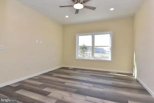 an empty room with a window and a ceiling fan
