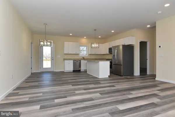 a view of kitchen with refrigerator cabinets and wooden floor