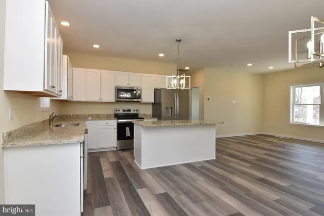 a kitchen with a refrigerator and a stove top oven