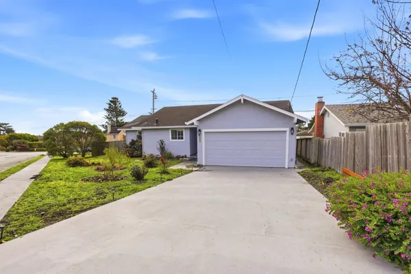 a front view of house with pathway and a fence