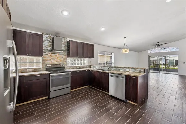 a large kitchen with stainless steel appliances kitchen island granite countertop a stove and a sink