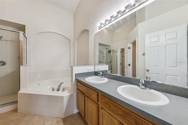 a bathroom with a granite countertop sink a mirror and a bathtub