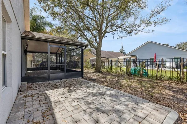 a view of a house with a small yard and a large tree