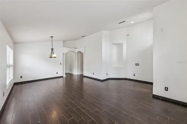 a view of a room with wooden floors and white walls