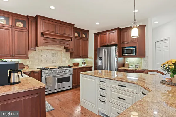 a kitchen with stainless steel appliances granite countertop stove top oven and cabinets