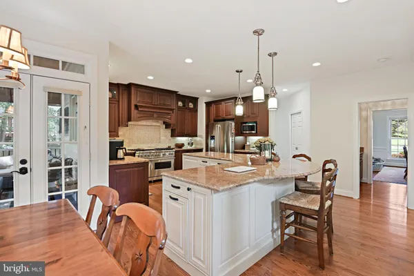 a dining room with furniture a chandelier and wooden floor