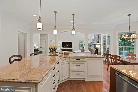 a view of a dining room and livingroom furniture wooden floor a rug and a chandelier