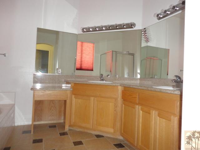 49473 Wayne Street Indio, CA 92201 - Photo 13 of 20 a bathroom with a granite countertop sink a mirror and a shower