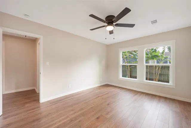 a view of a big room with wooden floor and windows