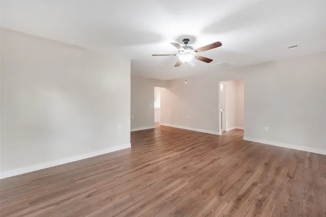 a view of an empty room with wooden floor