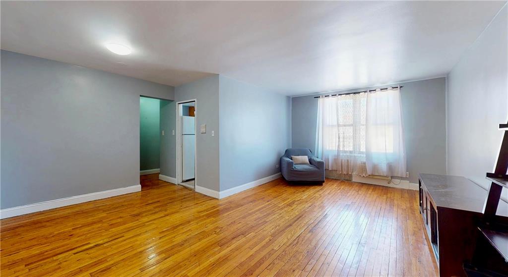 2909 Ocean Avenue, Unit 4E Brooklyn, NY 11235 - Photo 3 of 10 an empty room with wooden floor and windows