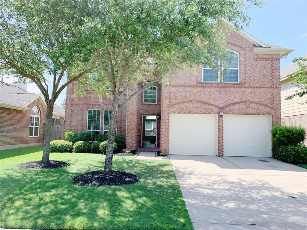 24418 Ranchwood Springs Lane Katy, TX 77494 - Photo 1 of 29 a front view of a house with a garden and trees