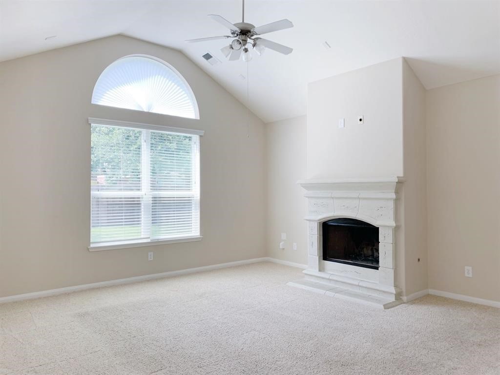24418 Ranchwood Springs Lane Katy, TX 77494 - Photo 13 of 29 an empty room with chandelier windows and fireplace