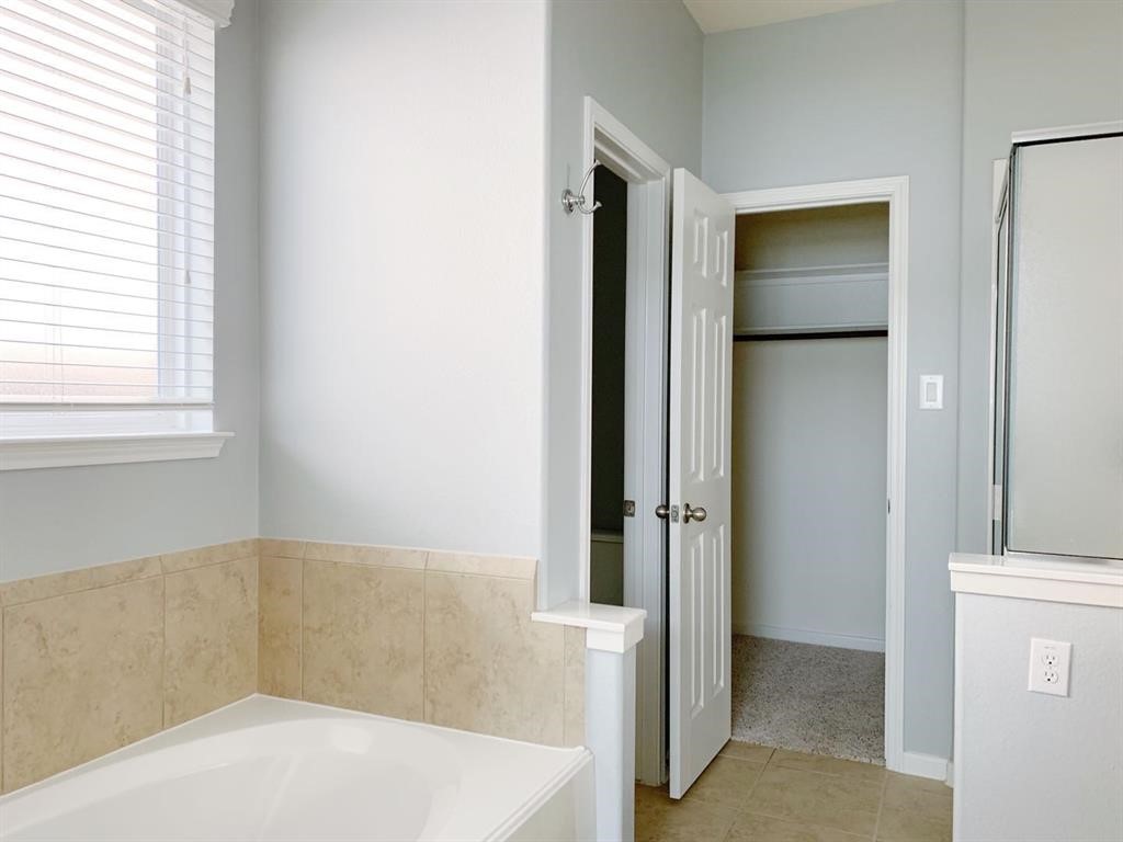 24418 Ranchwood Springs Lane Katy, TX 77494 - Photo 19 of 29 a bathroom with a bathtub and a shower