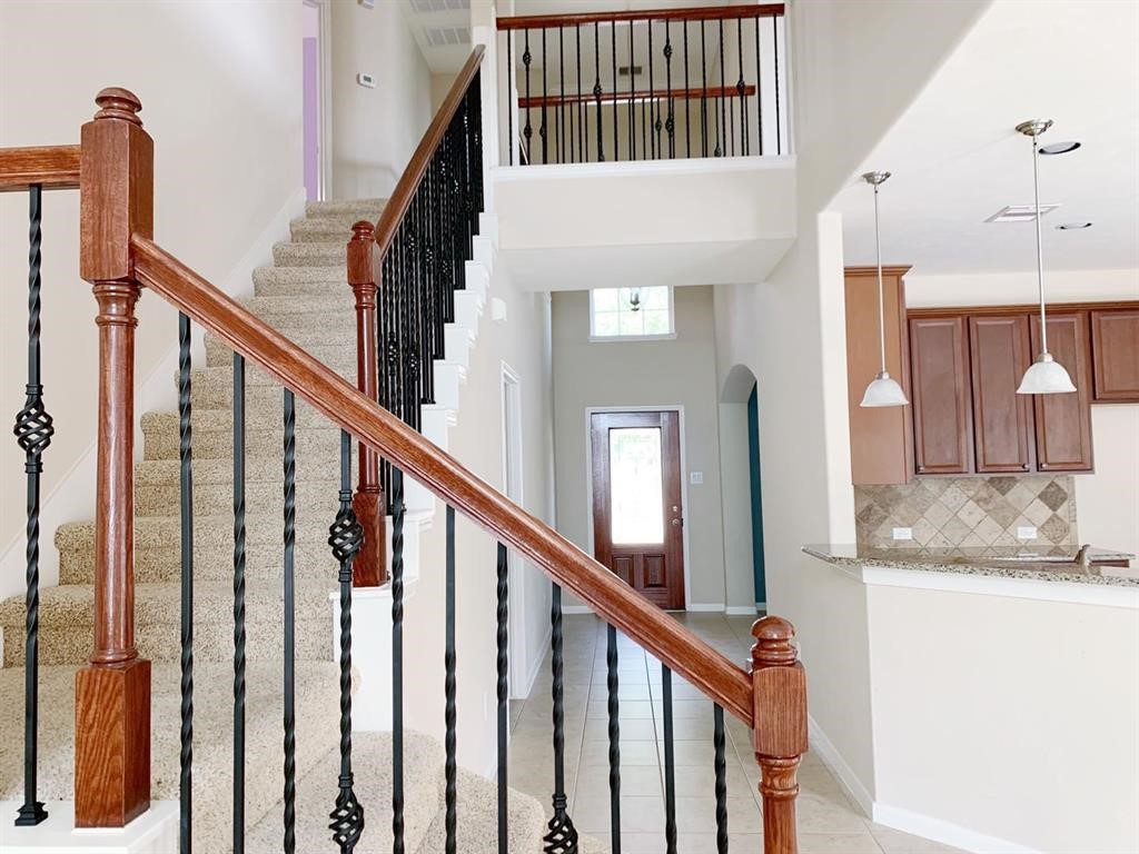 24418 Ranchwood Springs Lane Katy, TX 77494 - Photo 21 of 29 a view of staircase with railing and a chandelier