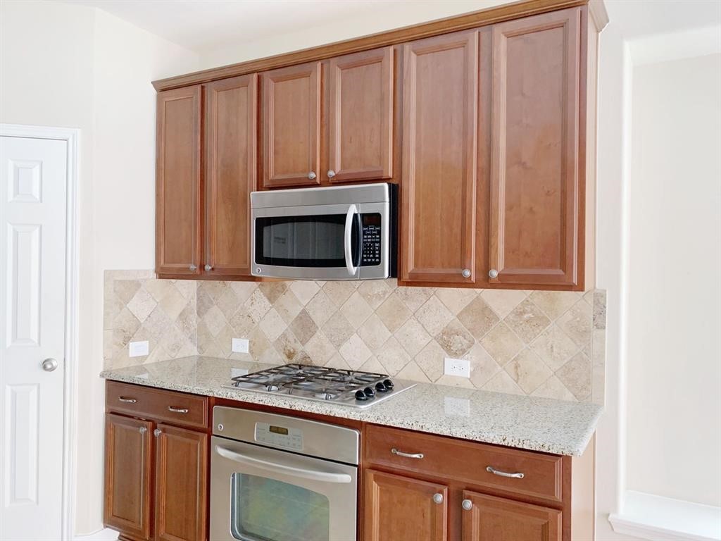24418 Ranchwood Springs Lane Katy, TX 77494 - Photo 9 of 29 a kitchen with granite countertop cabinets and fireplace