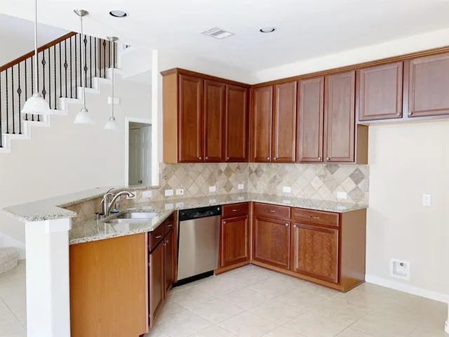 a kitchen with stainless steel appliances granite countertop a sink and cabinets