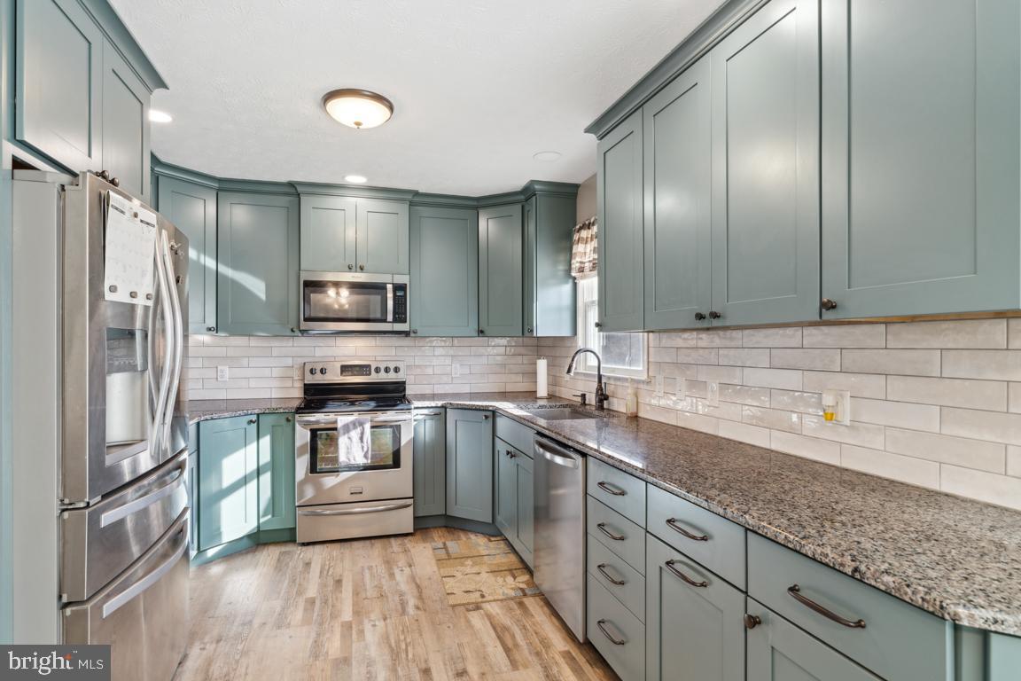 20 Cox Road Colora, MD 21917 - Photo 8 of 38 a kitchen with granite countertop stainless steel appliances a sink stove refrigerator and cabinets