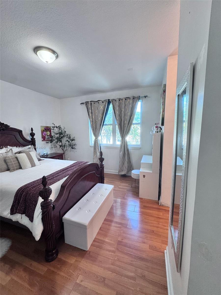 11041 Southwest 246th Street Homestead, FL 33032 - Photo 13 of 25 a spacious bedroom with a bed and a wooden floor