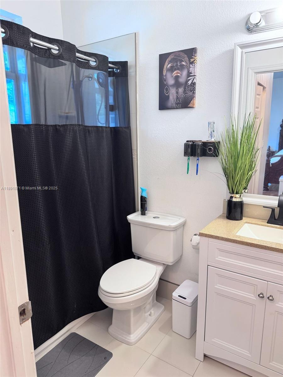 11041 Southwest 246th Street Homestead, FL 33032 - Photo 15 of 25 a white toilet sitting next to a shower curtain