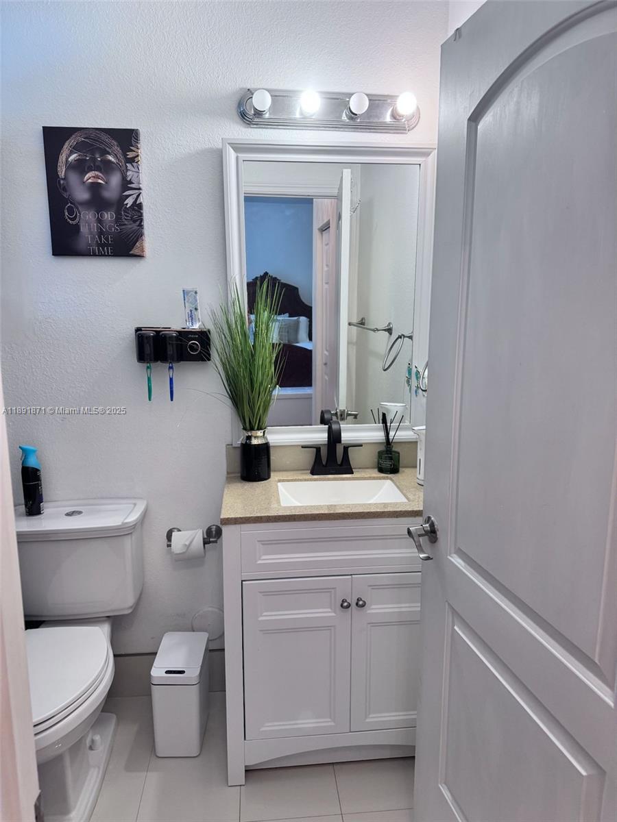 11041 Southwest 246th Street Homestead, FL 33032 - Photo 16 of 25 a bathroom with a toilet a sink and mirror
