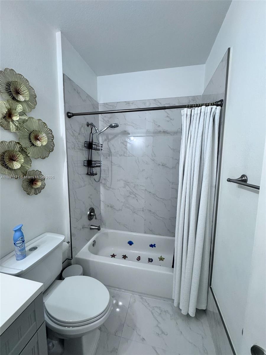 11041 Southwest 246th Street Homestead, FL 33032 - Photo 18 of 25 a white toilet sitting next to a bathroom sink and tub