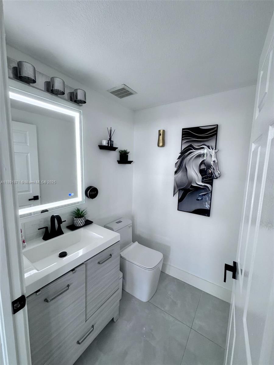 11041 Southwest 246th Street Homestead, FL 33032 - Photo 23 of 25 a bathroom with a toilet sink and mirror