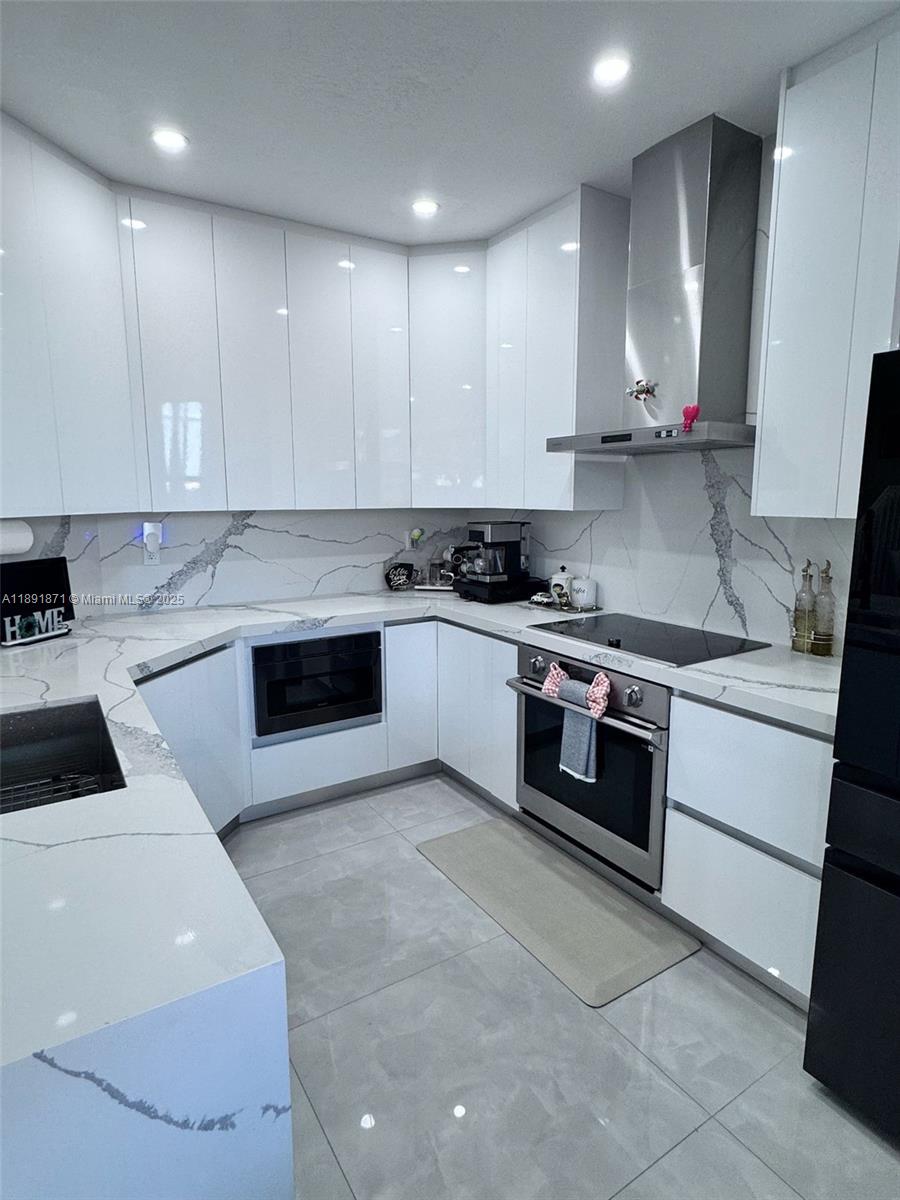 11041 Southwest 246th Street Homestead, FL 33032 - Photo 7 of 25 a kitchen with stainless steel appliances granite countertop a stove a sink and a microwave