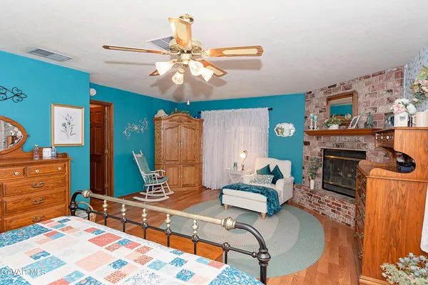 a bedroom with a bed a dresser and a chandelier