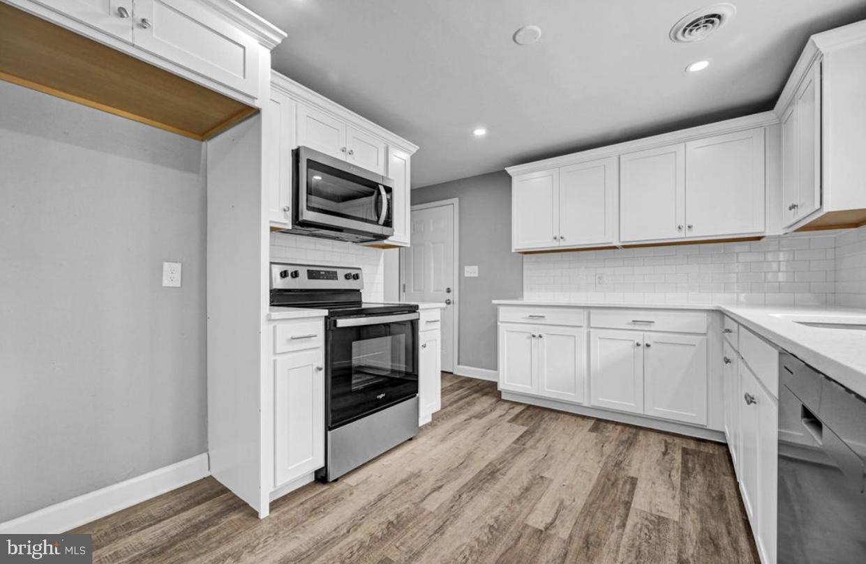 525 Mountain Road Dillsburg, PA 17019 - Photo 36 of 53 a kitchen with white cabinets stainless steel appliances and wooden floor