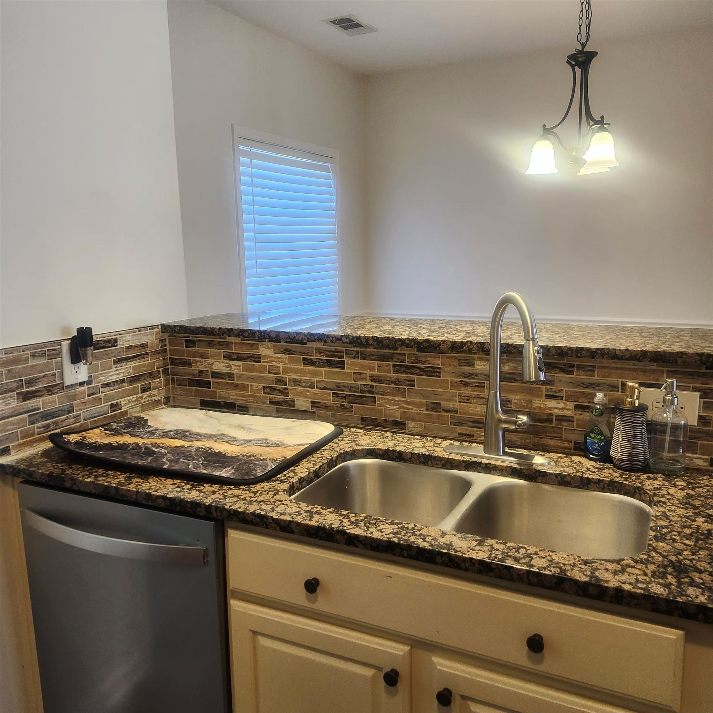 1497 Castle Pines Circle, Unit 18 Collierville, TN 38017 - Photo 11 of 23 Kitchen with stainless steel dishwasher, dark stone countertops, and pendant lighting