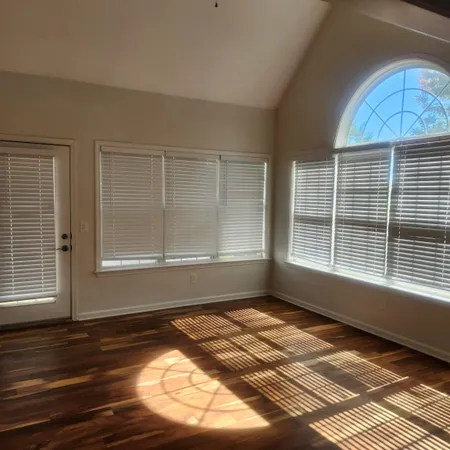a view of a room with wooden floor and a window