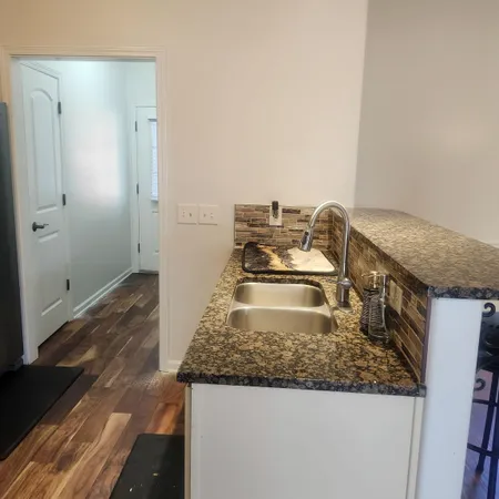 a kitchen with a granite countertop sink and stove