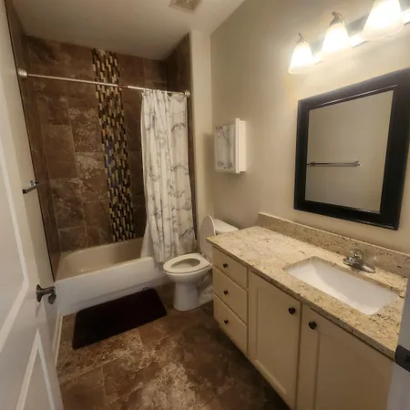 a bathroom with a granite countertop sink toilet and shower