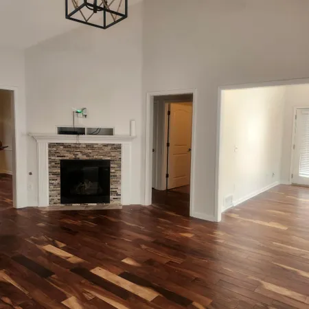 a view of a livingroom with a fireplace a desk and chair
