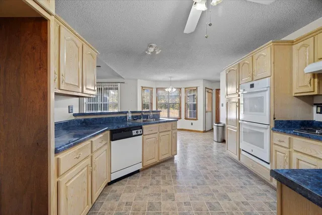 a kitchen with granite countertop a sink stove and refrigerator